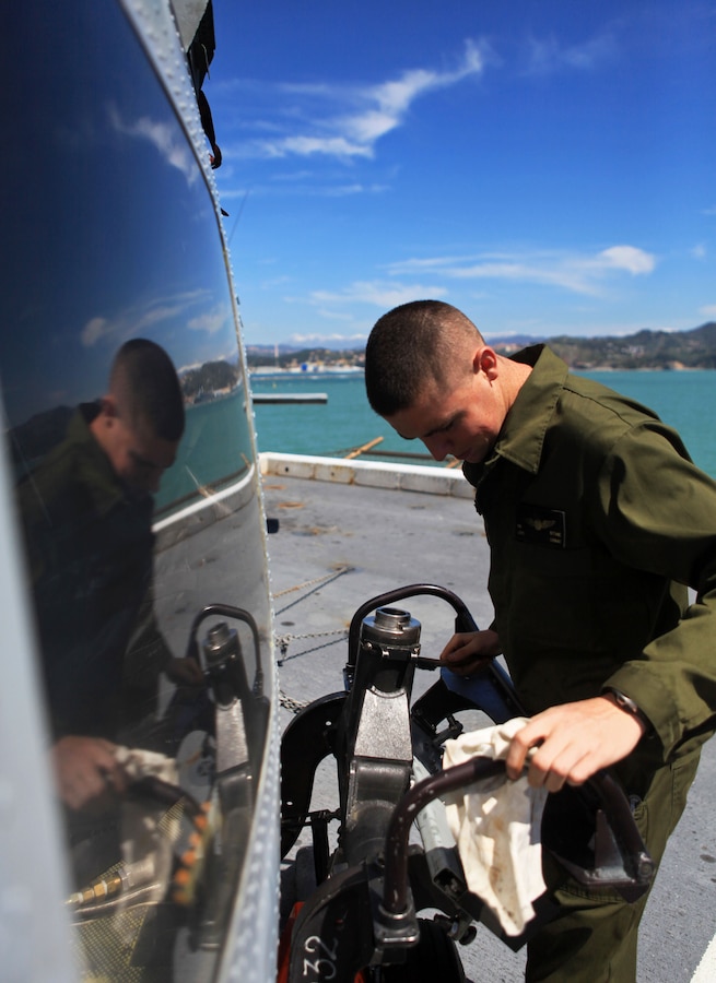 Lance Cpl. Robert Bridenstine, an aviation ordinance technician with Marine Medium Tiltrotor Squadron 261 (Reinforced), 24th Marine Expeditionary Unit, performs routine corrosion treatment on a AH-1W Cobra here as the ship departs La Spezia, Italy, April 26, 2012, after a port visit. The 24th MEU is currently deployed with the Navy's Iwo Jima Amphibious Ready Group as a theater reserve and crisis response force capable of a variety of missions from full-scale combat operations to humanitarian assistance and disaster relief.