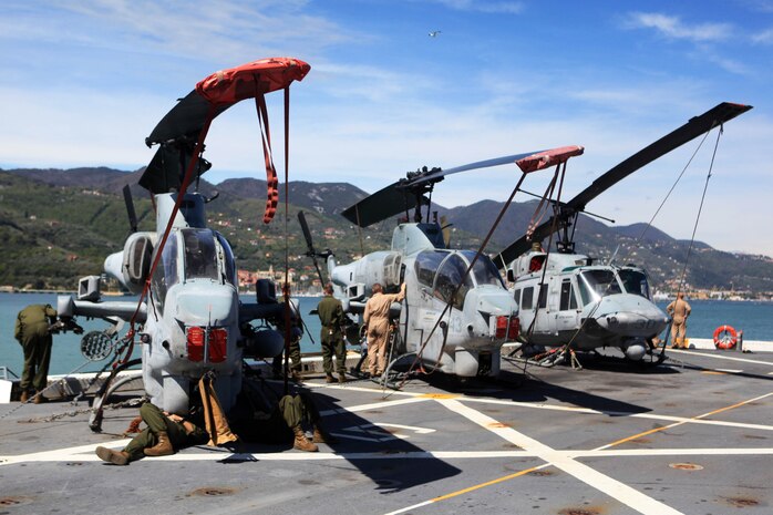 Marines with Marine Medium Tiltrotor Squadron 261 (Reinforced), 24th Marine Expeditionary Unit, perform routine corrosion treatment on AH-1W Cobras and a UH-1N Huey here as the ship departs La Spezia, Italy, April 26, 2012, after a port visit. The 24th MEU is currently deployed with the Navy's Iwo Jima Amphibious Ready Group as a theater reserve and crisis response force capable of a variety of missions from full-scale combat operations to humanitarian assistance and disaster relief.