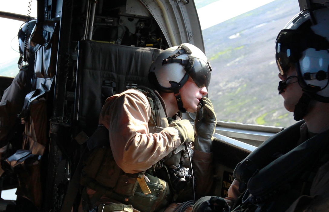 Lance Cpl. Anthony DiCola (center), a crew chief with Marine Transport Squadron 1, spots potential landing zones from the side window of the HH-46E Sea Knight, dubbed Pedro, during a three-hour training flight April 27. Cpl. Kyle Smith, a rescue swimmer with VMR-1 and Sgt. Zachary Wood, a crew chief and noncommissioned officer in charge with VMR-1 (right) assisted DiCola with his on-the-job training which ranged from Morehead City to New Bern pointing out different landing zones used during their rapid emergency response efforts.