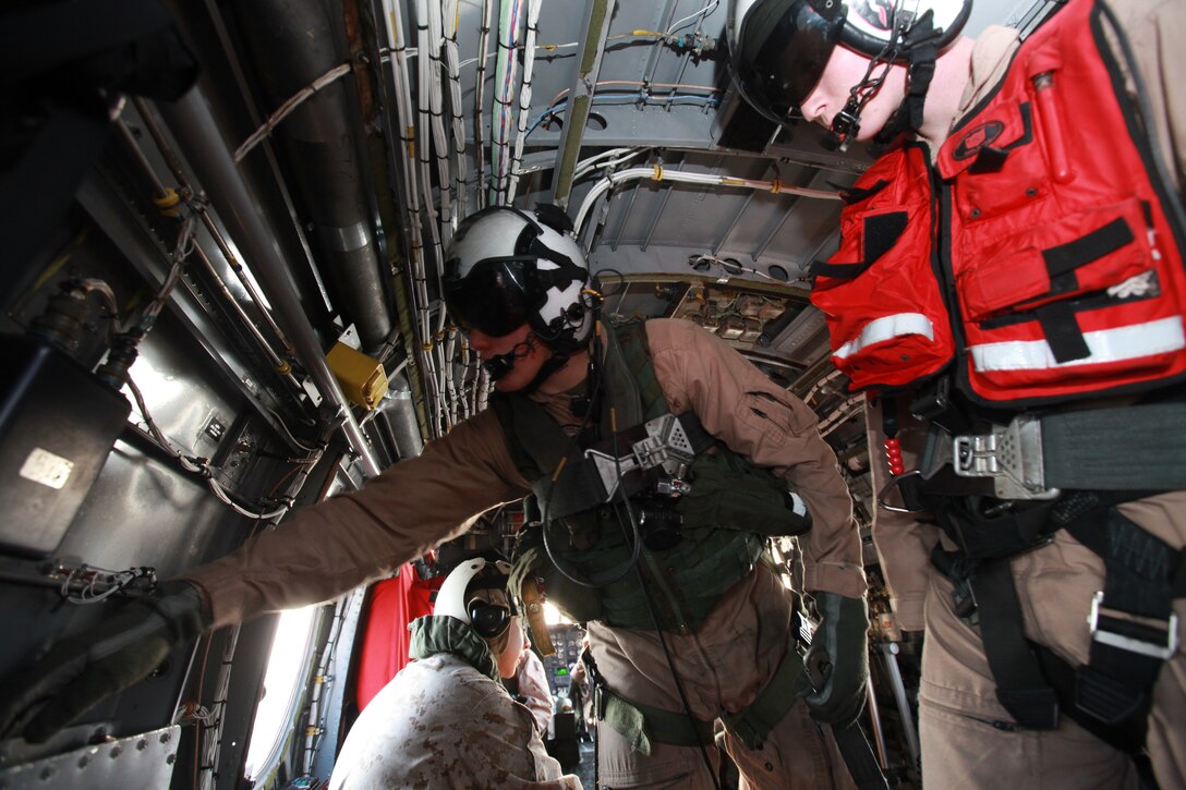 Cpl. Kyle Smith, a rescue swimmer with Marine Transport Squadron 1 (right), teaches Lance Cpl. Anthony DiCola, a crew chief with VMR-1, the uses of different pieces of equipment on the HH-46E Sea Knight, dubbed Pedro, April 27. The day’s mission included a range sweep to ensure fishermen, hunters and recreational boaters maintained appropriate clearances from target areas and spotting of the landing zones used by the squadron for rapid response missions.