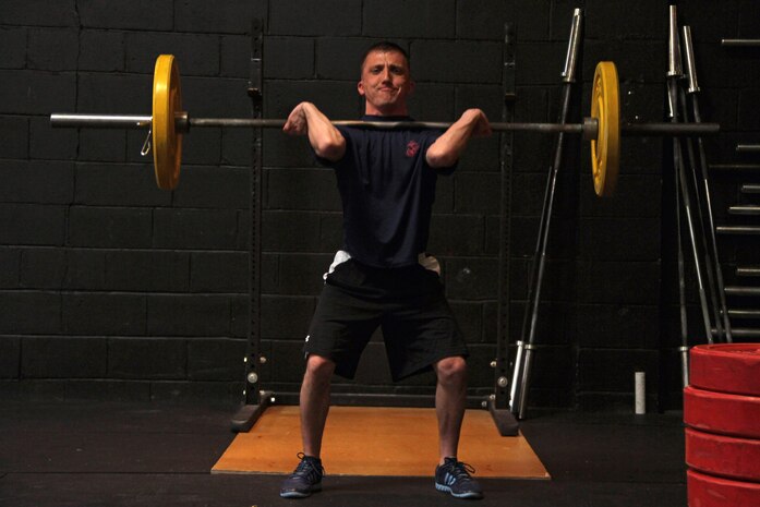 Sioux Falls, S.D., recruiter Sgt. David E. Packer, 25, from Salt Lake City, demonstrates cleans to his fellow Marines during a CrossFit re-certification course April 27. For additional imagery from the event, visit www.facebook.com/rstwincities.