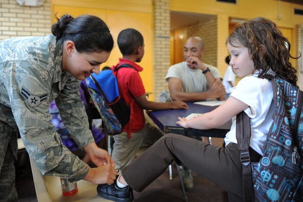Destiny Walker, 6, watches U.S. Air Force Airman 1st Class Ella Keith tie her shoe at the Boys and Girls Club in Goldsboro, N.C., April 26, 2012. Approximately 20 Airmen from Group 5/6 and the Eagles Club on Seymour Johnson Air Force Base volunteered more than two hours to provide mentorship to the children there and help improve the facility. Walker is from Goldsboro, N.C. Keith, 4th Civil Engineering Squadron emergency manager, hails from Lafayette, La. (U.S. Air Force photo/Airman 1st Class John Nieves Camacho/Released)