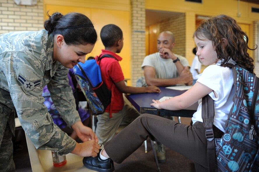 Destiny Walker, 6, watches U.S. Air Force Airman 1st Class Ella Keith tie her shoe at the Boys and Girls Club in Goldsboro, N.C., April 26, 2012. Approximately 20 Airmen from Group 5/6 and the Eagles Club on Seymour Johnson Air Force Base volunteered more than two hours to provide mentorship to the children there and help improve the facility. Walker is from Goldsboro, N.C. Keith, 4th Civil Engineering Squadron emergency manager, hails from Lafayette, La. (U.S. Air Force photo/Airman 1st Class John Nieves Camacho/Released)