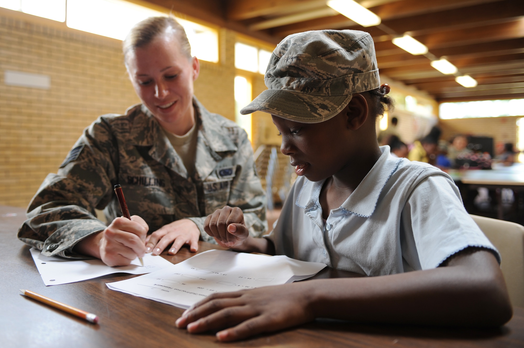 U.S. Air Force Staff Sgt. Laura Schilling helps Janaysia Hooker,7, with her homework during power hour at the Boys and Girls Club in Goldsboro, N.C., April 26, 2012. Power hour gives children 60 minutes to complete their homework before rotating to the next scheduled activity. Schilling, 4th Logistics Readiness Squadron flight service center supervisor, hails from Freeburg, Ill. Janaysia is a native of Goldsboro, N.C. (U.S. Air Force photo/Airman 1st Class John Nieves Camacho/Released)