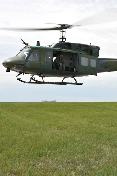 MINOT AIR FORCE BASE, N.D. -- Senior Airman Dan Vehslage, 54th Helicopter Squadron flight engineer, ensures the UH-1N Huey is clear for take-off here April 26. Helicopters can transport security forces and guard missile convoys transporting equipment or tactically insert members anywhere throughout the plains to react to security situations at missile complexes. (U.S. Air Force photo/Senior Airman Brittany Y. Auld)