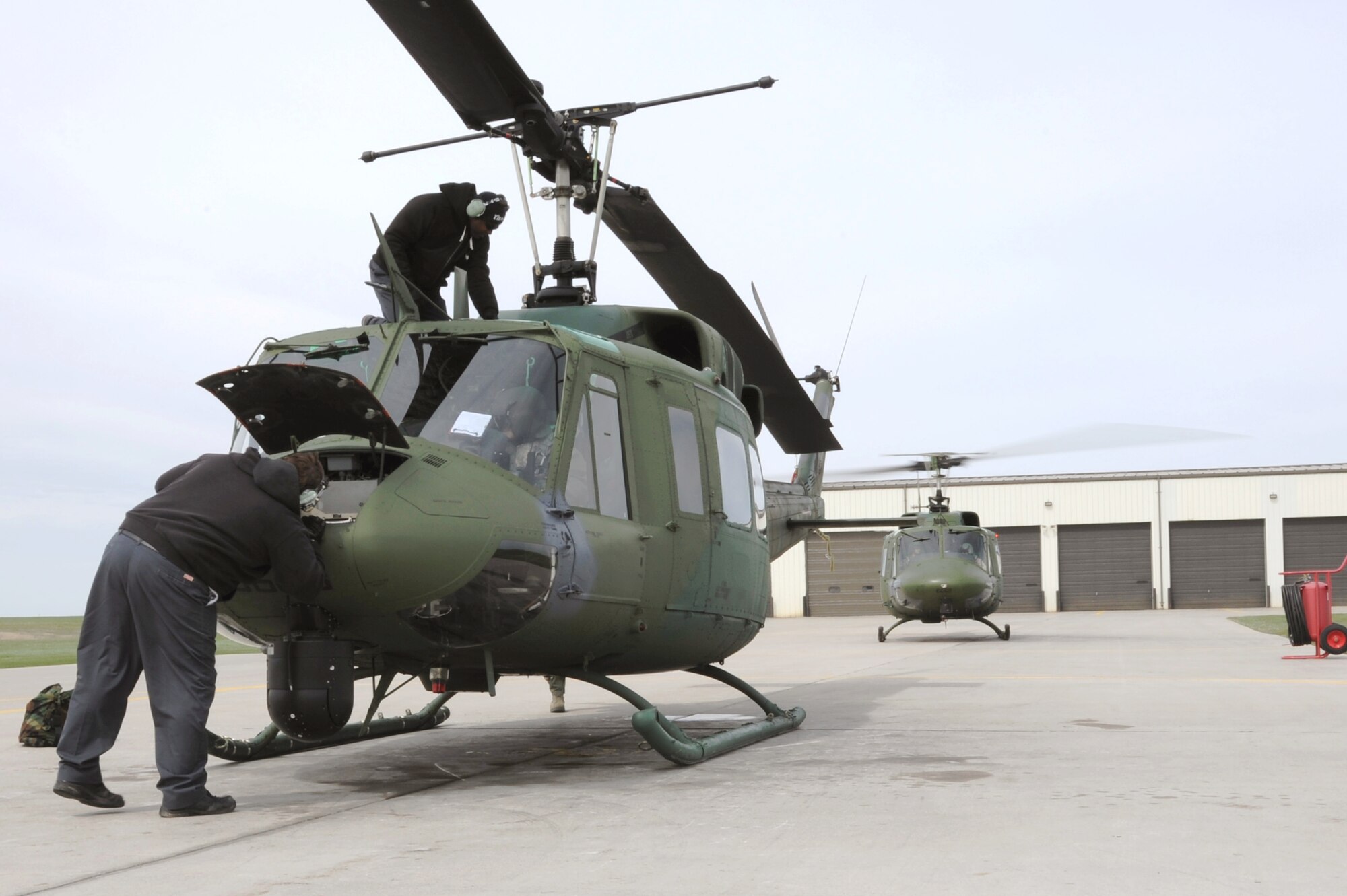 MINOT AIR FORCE BASE, N.D. -- Mechanics from the 54th Helicopter Squadron, perform a post flight inspection on a UH-1N Huey here April 26. The 54th HS allows the Air Force to respond quickly and effectively to emergency situations in a timely manner. (U.S. Air Force photo/Senior Airman Brittany Y. Auld)