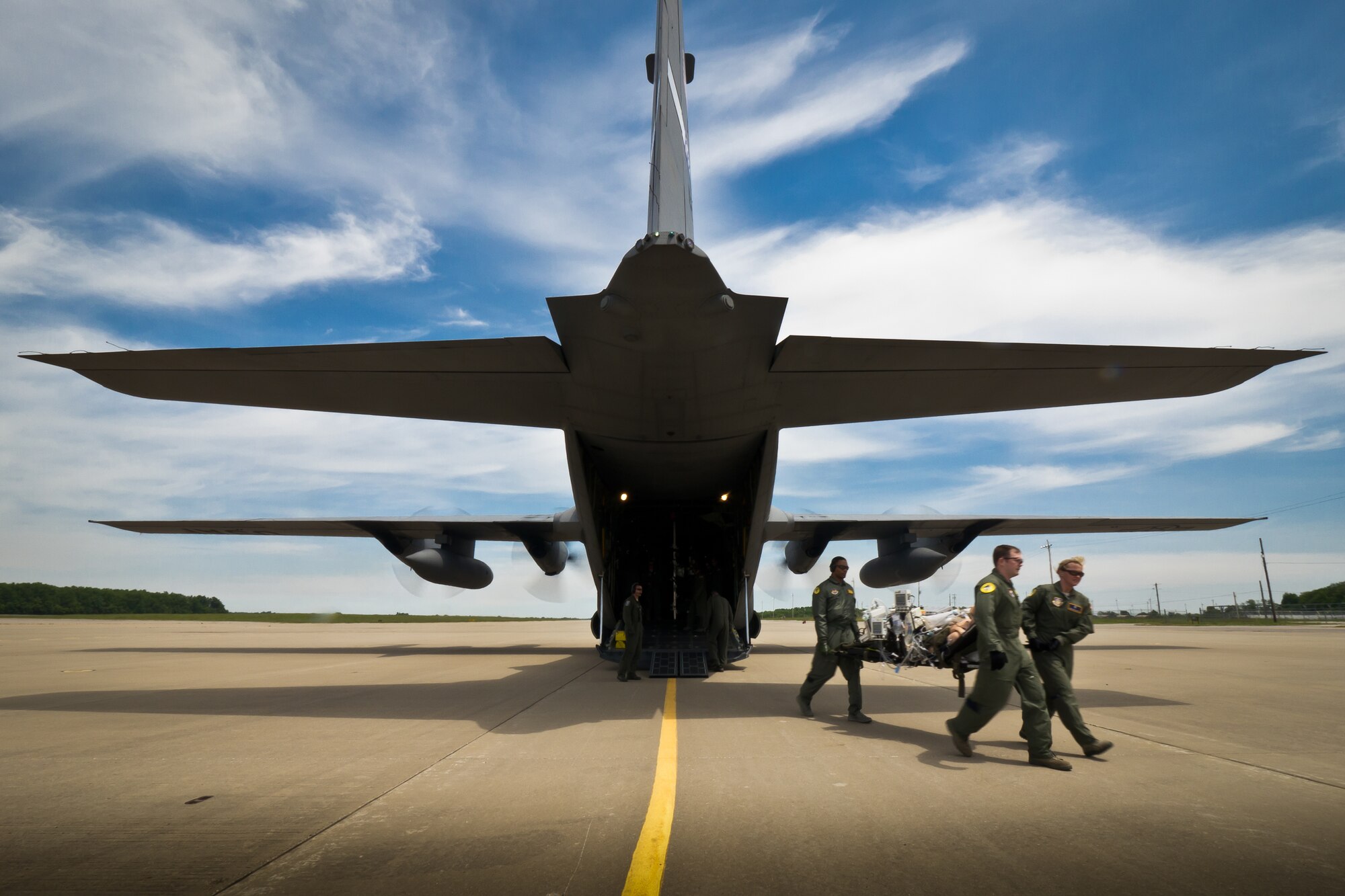 Airmen participating in a Critical Care Air Transport Team training course offload patient mannequins from a Kentucky Air National Guard C-130 as the aircraft's engines generate a substantial amount of prop blast on the flight line at Fort Campbell, Ky., April 27, 2012. The CCATT course is taught by instructors at the Air Force Center for Sustainment of Trauma and Readiness Skills at the University of Cincinnati and is designed to provide Air Force doctors, nurses and respiratory therapists with total immersion in the care of severely injured patients. The Kentucky Air Guard's 165th Airlift Squadron began providing C-130s to use as a CCATT training platform in 2009. (U.S. Air Force photo by Maj. Dale Greer)