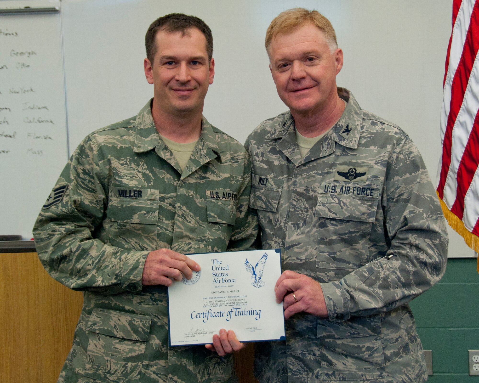 Colonel Ronald A. Wilt, commander of the 934th Airlift Wing Operations Group, presents a graduation certificate to Staff Sergeant James Miller of the 934th Airlift Wing Aeromedical Staging Squadron for his completion of the Leadership Development Course, March 27, 2012. (US Air Force Photo/ Tech Sgt Jim Loehr)