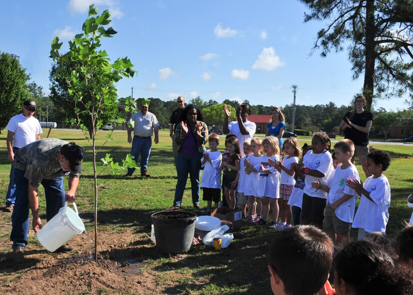 John Crain, 23d Civil Engineer Squadron forester, waters a newly planted yellow poplar tree during Arbor Day at Moody Air Force Base, Ga., April 27, 2012. Crain informed children about the three components necessary for trees to grow:  water, soil and sun. (U.S. Air Force photo by Staff Sgt. Stephanie Mancha/ Released)

