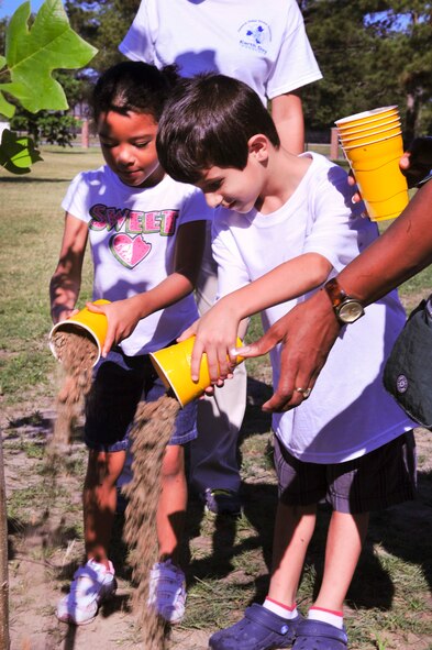 Alanah Debro, daughter of U.S. Air Force Staff Sgt. Crystal Mathis, 23d Logistic Readiness Squadron, and Preston Grover, son of Senior Airman Joshua Grover, 723d Aircraft Maintenance Squadron, pour dirt onto a newly planted tree for Arbor day at Moody Air Force Base, Ga., April 27, 2012. Children from the Georgia Pre-K Program at the child development center on base participated in Moody’s Arbor Day celebration by helping plant a tree at Tree City USA Park on Moody. (U.S. Air Force photo by Staff Sgt. Stephanie Mancha/Released)