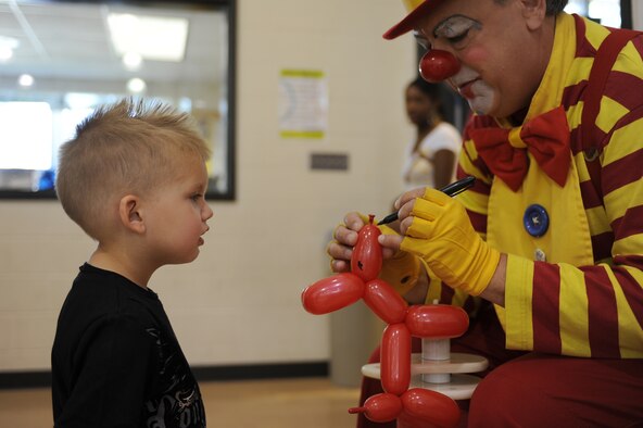 Trevor Acord, 3, watches as Ubi the Clown makes a dog during the Month of Military Child information fair on Seymour Johnson Air Force Base, N.C., April 21, 2012. Since 1991, Ubi has been involved in countless performances, shows, celebrations and festivals performing clown magic, comedic juggling, and balloon twisting. Trevor is the son of U.S. Air Force Staff Sgt. Timothy Acord a 4th Equipment Maintenance Squadron munitions inspector from Beckley, W.Va. (U.S. Air Force photo/Airman 1st Class John Nieves Camacho/Released)