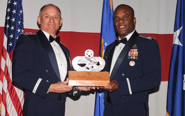 U.S. Air Force Col. Neal Robinson, 23d Maintenance Group commander, presents a maintenance badge plaque to Maj. Gen. Mark Atkinson, Air Combat Command director of logistics, during the 2011 Maintenance Professional of the Year banquet at the James H. Rainwater Conference Center in Valdosta, Ga., April 26, 2012. The plaque was presented to Atkinson to symbolize the 23d MXG’s appreciation for his attendance at the banquet. (U.S. Air Force photo by Airman 1st Class Douglas Ellis/Released)
