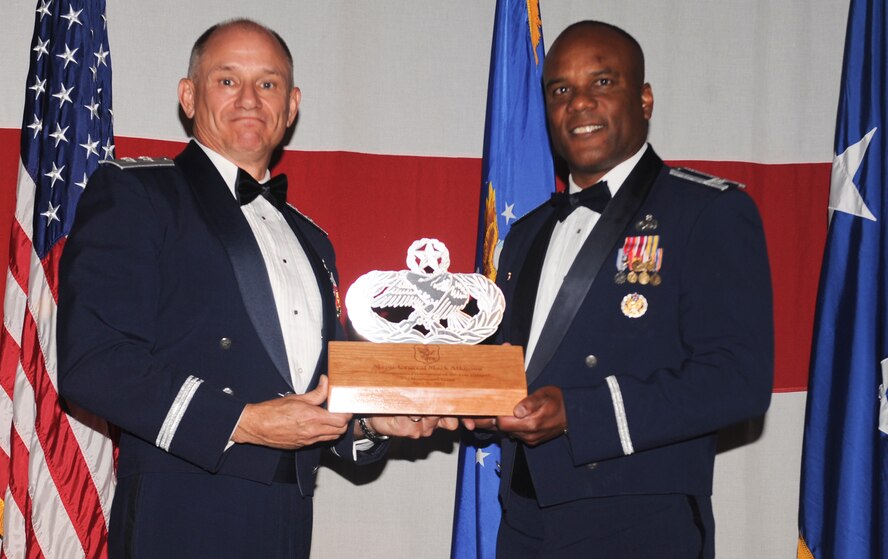 U.S. Air Force Col. Neal Robinson, 23d Maintenance Group commander, presents a maintenance badge plaque to Maj. Gen. Mark Atkinson, Air Combat Command director of logistics, during the 2011 Maintenance Professional of the Year banquet at the James H. Rainwater Conference Center in Valdosta, Ga., April 26, 2012. The plaque was presented to Atkinson to symbolize the 23d MXG’s appreciation for his attendance at the banquet. (U.S. Air Force photo by Airman 1st Class Douglas Ellis/Released)
