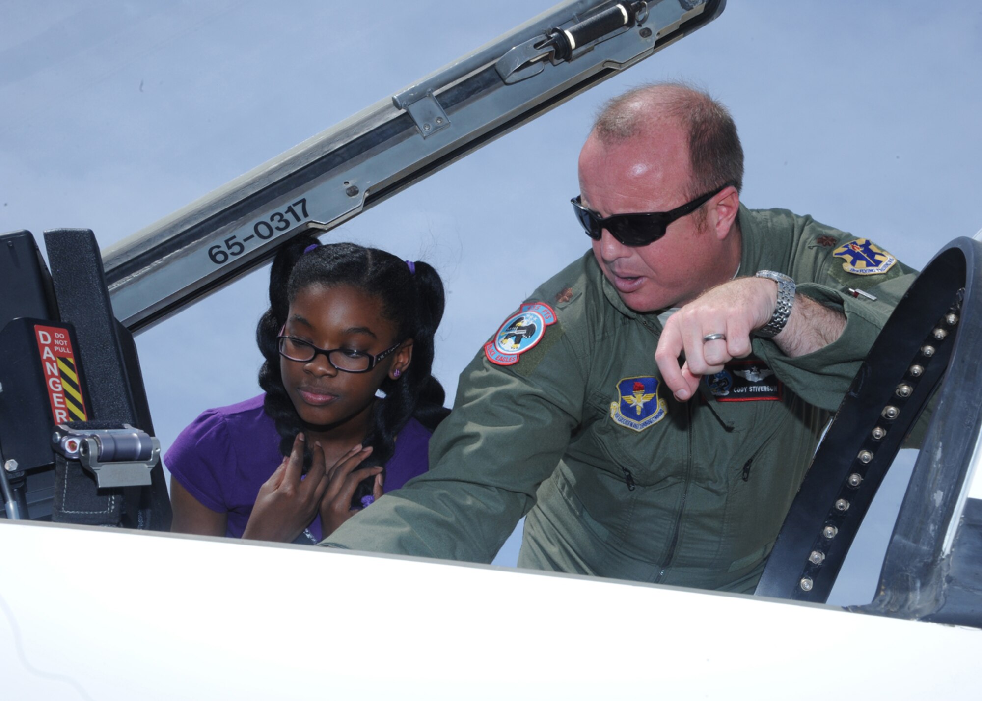 Maj. Cody Stevens, 435th Fighter Training Squadron instructor pilot, shows Sydney Sylvester, daughter of Anissa Sylvester, Air Force Personnel Center, the inside of a T-38 Talon aircraft at Joint Base San Antonio-Randolph April 26. AFPC held a "Take Your Daughters & Sons to Work" as part of Month of the Military Child. (U.S. Air Force photo/Rich McFadden)