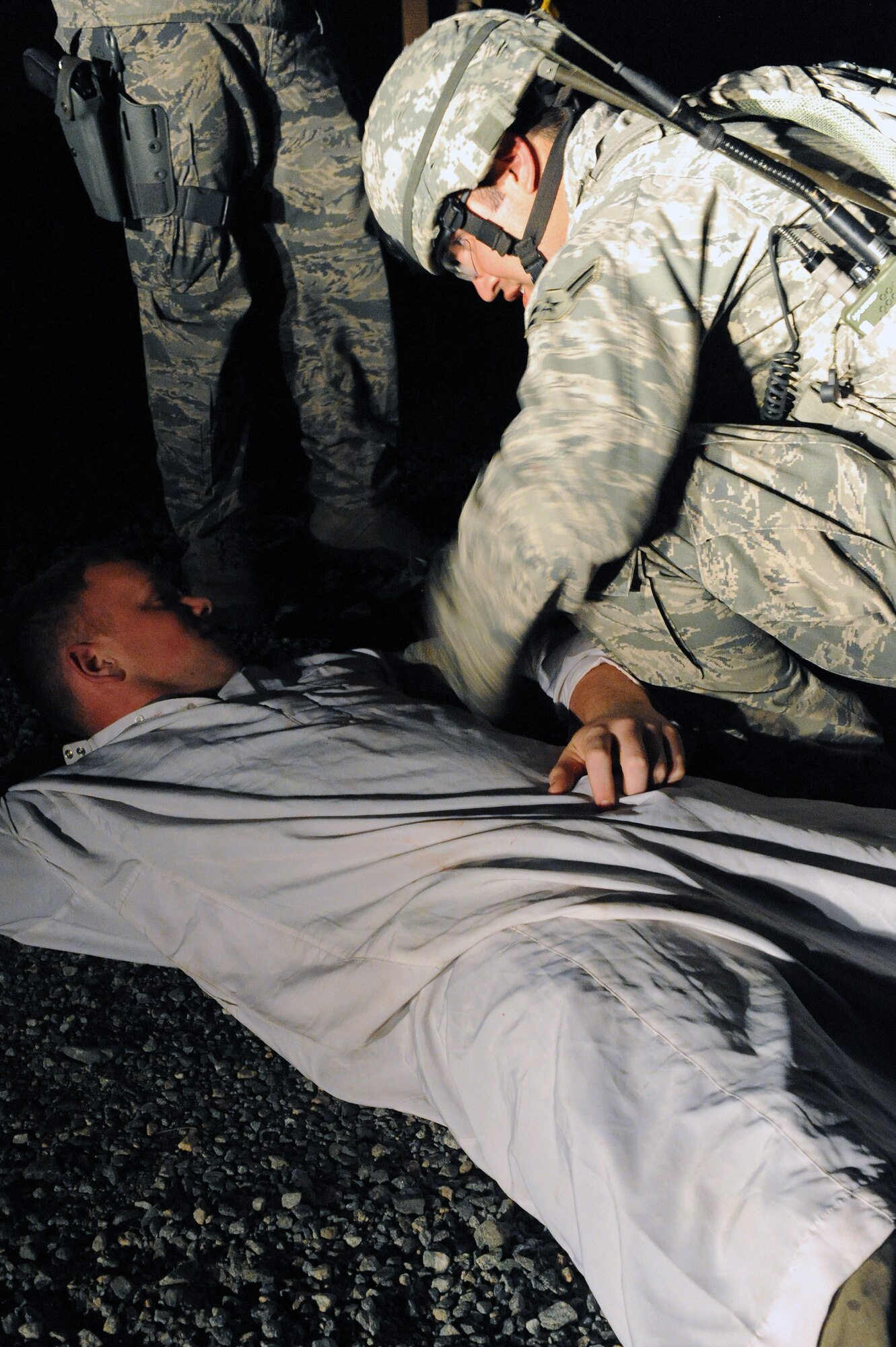 U.S. Air Force Airman 1st Class Jason Crawford, 824th Base Defense Squadron, practices first aid on an Airman acting as an Afghan civilian at Moody Air Force Base, Ga., April 25, 2012. Airmen assigned to the 820th Base Defense Group conducted an operational readiness exercise to test their members’ ability to respond to threats effectively. (U.S. Air Force photo by Staff Sgt. Ciara Wymbs/Released)