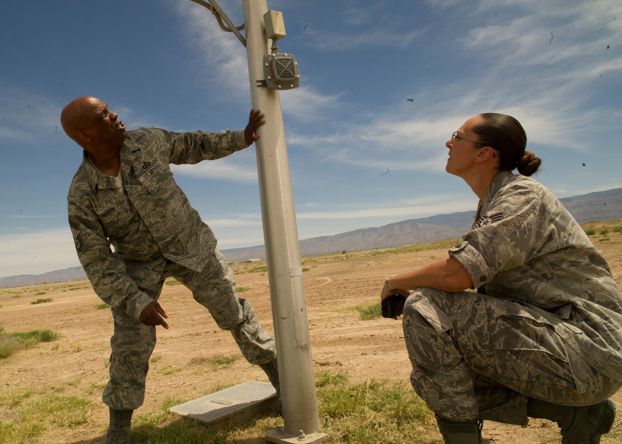 HOLLOMAN AIR FORCE BASE, N.M. – Chief Master Sgt. Warren Harper, Airfield Operations Compliance Inspection team member, and Staff Sgt. Sherresa Lasseter, 49th OSS airfield manager, check the frangibility, or bend ability, of a pole on the airfield April 25. Harper inspected all objects that were within 1,000 feet of the runway centerline for their frangibility. If items do not meet the frangibility regulations to be on the airfield, they must be burrowed underground, relocated or demolished. (U.S. Air Force photo by Airman 1st Class Siuta B. Ika/ Released)