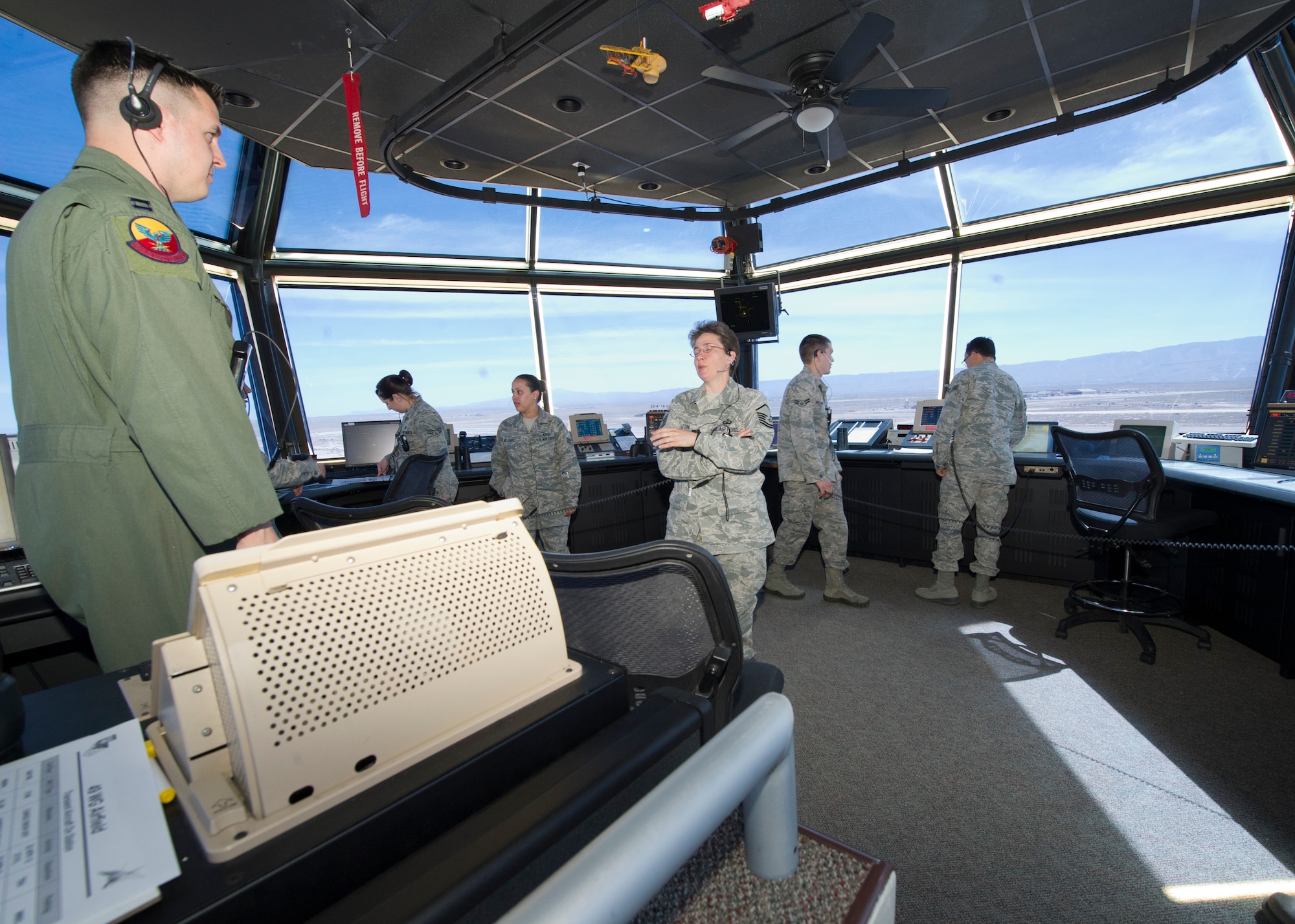 HOLLOMAN AIR FORCE BASE, N.M. – Master Sgt. Lisa Melton (center), Airfield Operations Compliance Inspection team member, speaks to a member of the air traffic control team during her evaluation of the ATC tower’s operators April 25. Melton evaluated the ATC tower’s operations to ensure all of the operators were working in compliance with U.S. Air Force and Federal Aviation Administration regulations. Melton and other AOCI team members inspected all operations of the airfield to ensure the airfield environment is safe of any hazards and to make sure Holloman AFB is providing a safe flying environment to all local and transient aircraft. (U.S. Air Force photo by Airman 1st Class Siuta B. Ika/ Released)