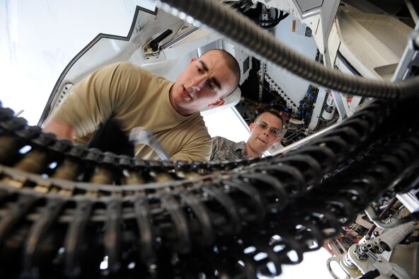 Air Force Airman 1st Class Joseph Celona loads 20-milimeter rounds into an F-22 Raptor using a universal ammunication loading system under the supervision of Air Force Staff Sgt. Joel Bass on the flight line at Joint Base Elmendorf-Richardson, Alaska, April 25.  An F-22 pilot will later fire the rounds at a target banner as training for combat operations. (U.S. Air Force photo/Staff Sgt. Robert Barnett)