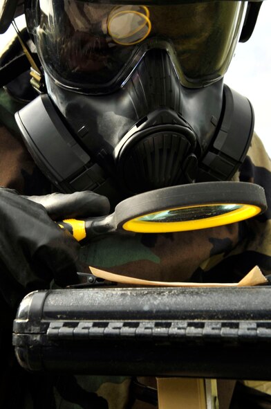 An Airman inspects a piece of M9 paper for contamination during a chemical, biological, radiological, nuclear, and explosive training drill. (U.S. Air Force photo by Airman Nicole Sikorski)