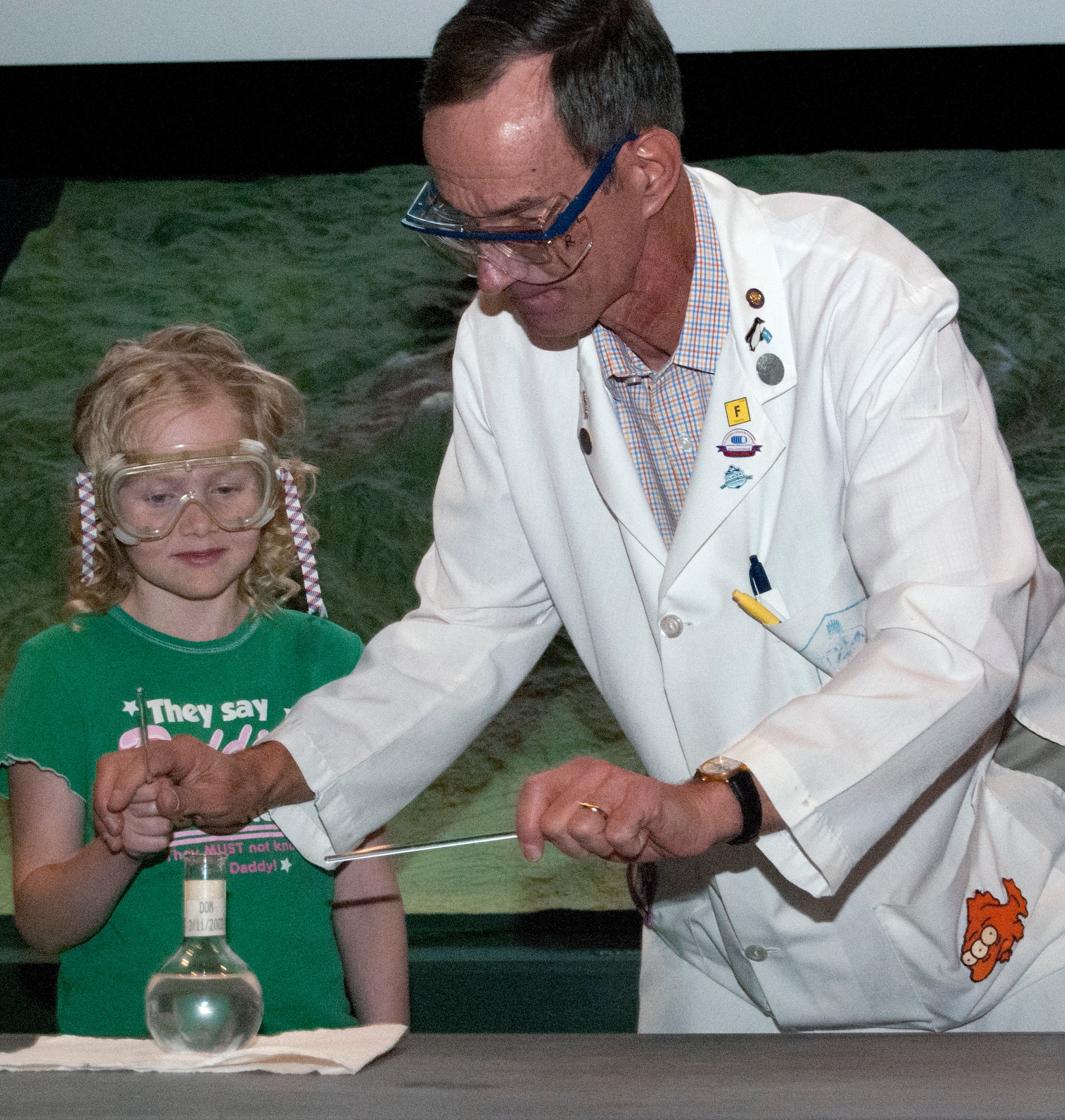 Dr. Ron Furstenau conducts a chemistry experiment with Becka as part of a chemistry magic show at the Garden of the Gods Visitor and Nature Center April 21, 2012. Furstenau, an instructor with the Air Force Academy's Chemistry Department, has performed chemistry magic shows since his first tour here in 1984. (U.S. Air Force photo/Don Branum)