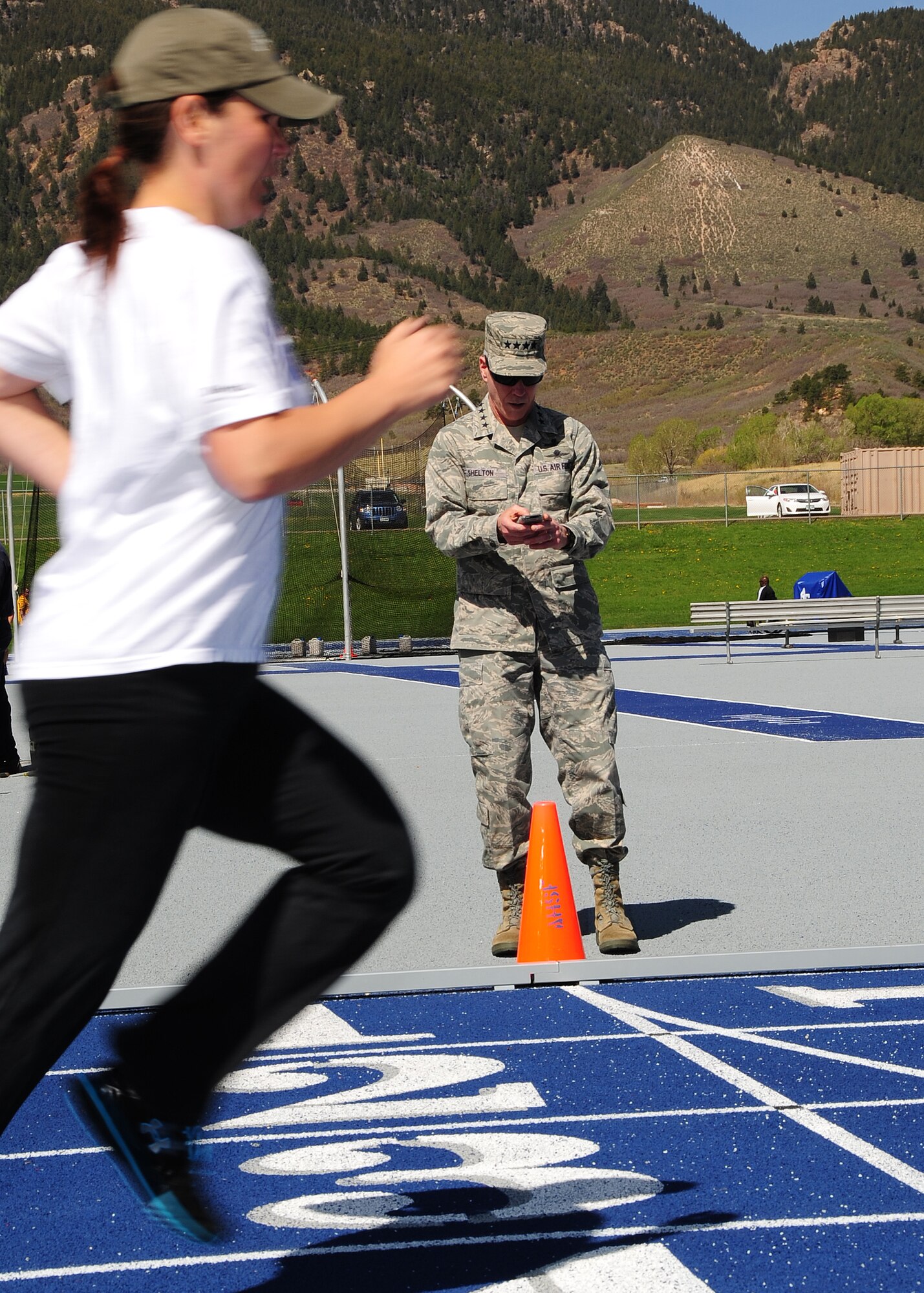 Gen. William L. Shelton, Commander, Air Force Space Command, keeps the time for retired Staff Sgt. Stacy Pearsall who is competing in the Warrior Games at the U.S. Air Force Academy, Colo. April 25. Warrior Games serves as an introduction to Paralympic sport, while at the same time builds camaraderie and raises awareness of adaptive sports. (U.S. Air Force photo/Duncan Wood)