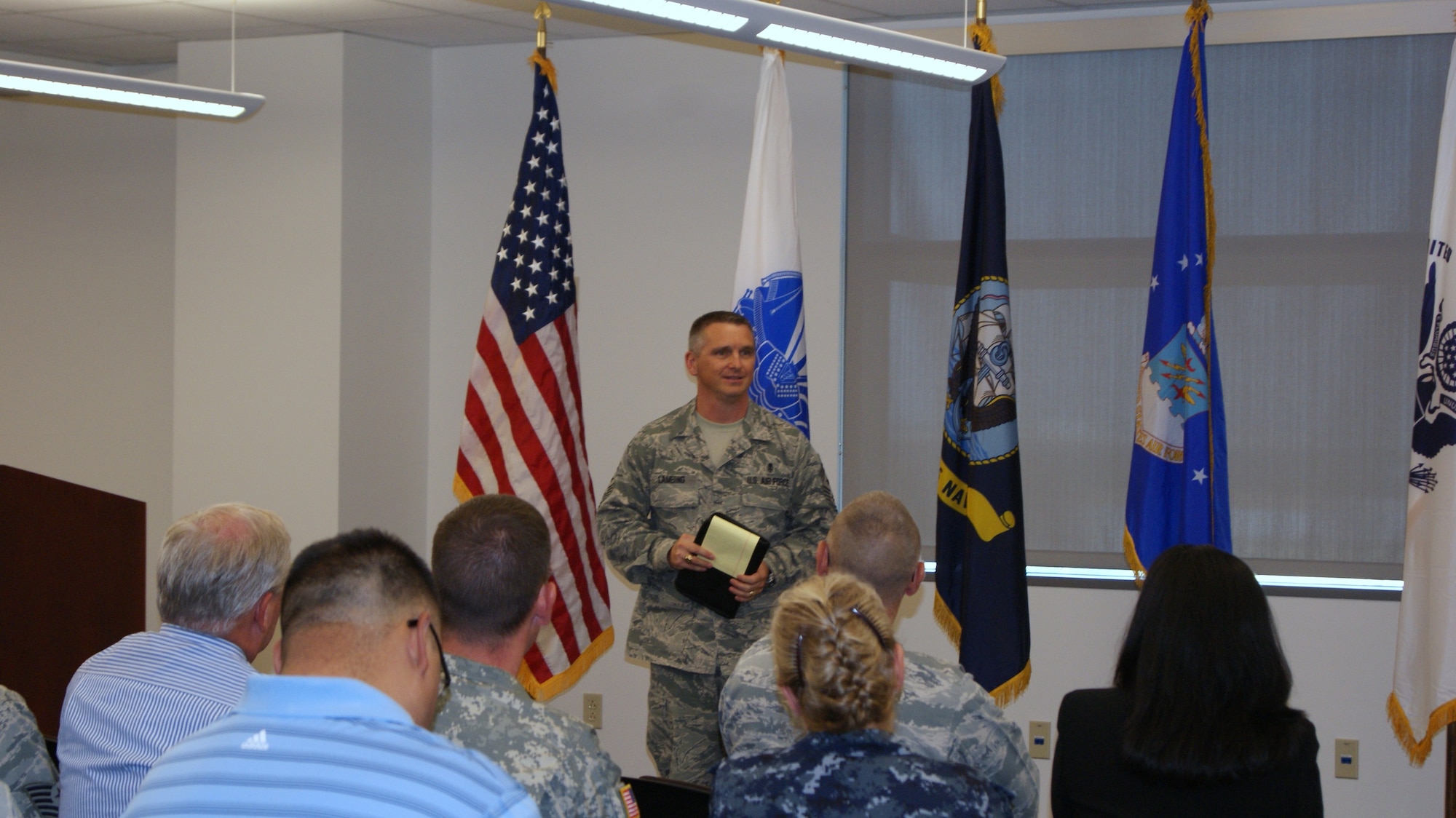 Chief Master Sgt. Kevin Lambing briefs a joint group of service members and civilians at the Medical Education and Training Campus at Fort Sam Houston, Texas, recently. Lambing was inducted into the Army's Order of the Military Medical Merit April 20. (U.S. Army photo)