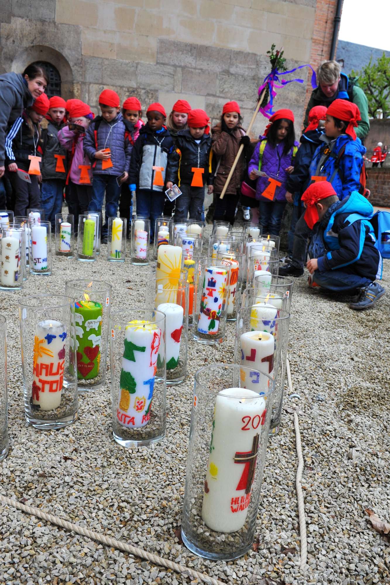 TRIER, Germany – Children from the Catholic Kindergarten St. Nikolaus  in Konz light a candle decorated by their class outside the Trier Dom Cathedral here April 25. Children from schools around Germany decorated candles in commemoration of the 500th anniversary of the first public appearance of the “Holy Robe,” a tunic reportedly worn by Jesus.  Approximately 700,000 pilgrims visited the relic at its last appearance at the cathedral in 1996. (U.S. Air Force photo by 2nd Lt. Stephani Schafer/Released)