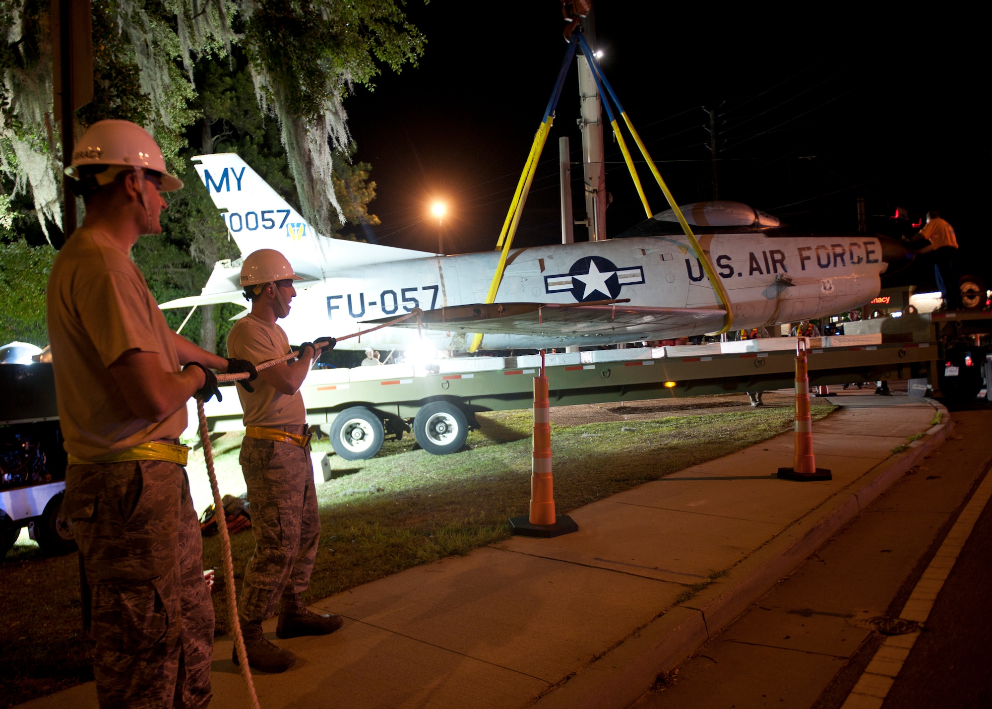 U.S. Air Force Staff Sgts. Ryan Adams-Brady and Christopher Matthews, 23d Equipment Maintenance Squadron, assist in guiding an F-86L Sabre onto a flatbed trailer that will transport it to Moody Air Force Base, Ga., April 24, 2012. The aircraft will be refurbished and then moved to the George W. Bush Air Park at Moody Field to commemorate the late Maj. Lyn McIntosh and the Flying Tigers heritage. (U.S. Air Force photo by Senior Airman Eileen Meier/Released)
