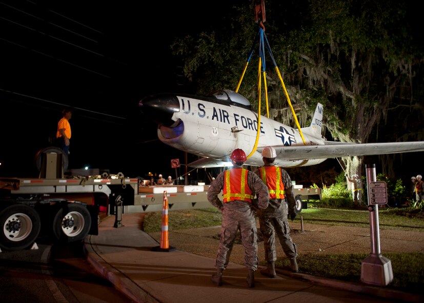 Airmen from Moody Air Force Base look on as an F-86L Sabre is lifted off its mount by a crane and placed on a flatbed trailer for transport to the base April 24, 2012.  A rededication ceremony will take place in the future to commemorate the late Maj. Lyn McIntosh and to represent the heritage of the Flying Tigers at the George W. Bush Air Park at Moody Field. (U.S. Air Force photo by Senior Airman Eileen Meier/Released)