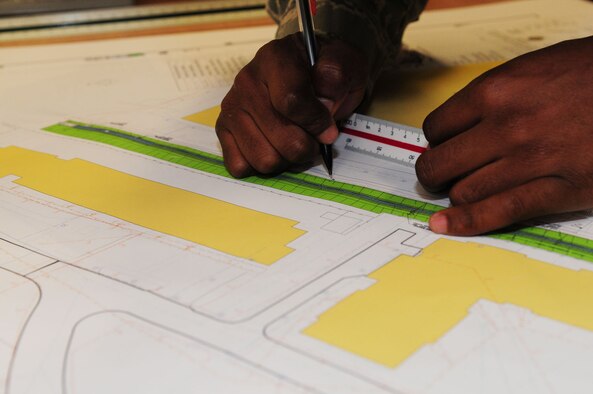 RAF MILDENHALL, England – Senior Airman Erik Hollomon, 100th Civil Engineer Squadron Geobase flight, checks the scale on a drainage map,  to ensure everything is accurate before he inputs the information into the flight’s map database April 16, 2012, at Building 680. In turn, the information helps to produce vital maps of every area on base, including buildings, electrical points, plumbing, fire hydrants and grassy areas. The information is used for many things including command and control for real-world and exercise incidents, road closures, and planning for new buildings. (U.S. Air Force photo/Karen Abeyasekere)