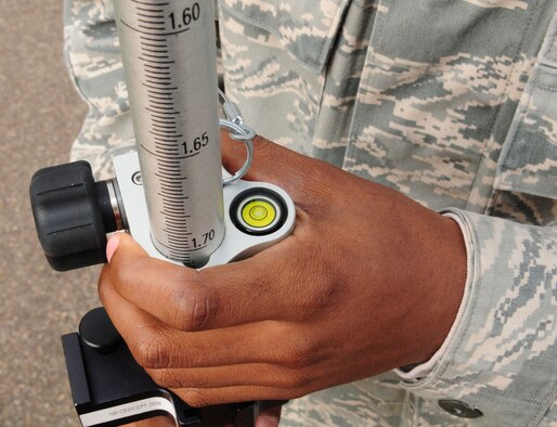 RAF MILDENHALL, England -- An Airman from the 100th Civil Engineer Squadron Geobase flight holds a global positioning system prism stand, April 16, 2012, outside Building 680, while ensuring the bubble is aligned in the center. The prism, used in conjunction with a total station (surveying equipment), gives precise measurements which the geobase Airmen use to build maps of the base. (U.S. Air Force photo/Karen Abeyasekere)