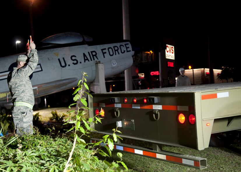 U.S. Air Force Tech. Sgt. John Turner, 23d Logistics Readiness Squadron, guides a flatbed trailer into position for an F-86L Sabre to be transported to Moody Air Force Base, Ga., April 24, 2012. The aircraft is a memorial for late Maj. Lyn McIntosh, a Valdosta native killed during a rescue attempt for American hostages in Iran in 1980. (U.S. Air Force photo by Senior Airman Eileen Meier/Released)