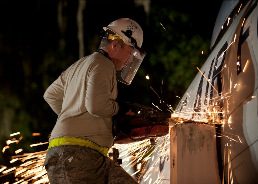 U.S. Air Force Staff Sgt. Christopher Dewitt, 23d Equipment Maintenance Squadron, uses a saw to remove the mounting bolts from the support of an F-86L Sabre in downtown Valdosta, Ga., April 24, 2012.  The aircraft will be refurbished and put on display at the George W. Bush Air Park at Moody Field as an addition to the Flying Tigers heritage. (U.S. Air Force photo by Senior Airman Eileen Meier/Released)