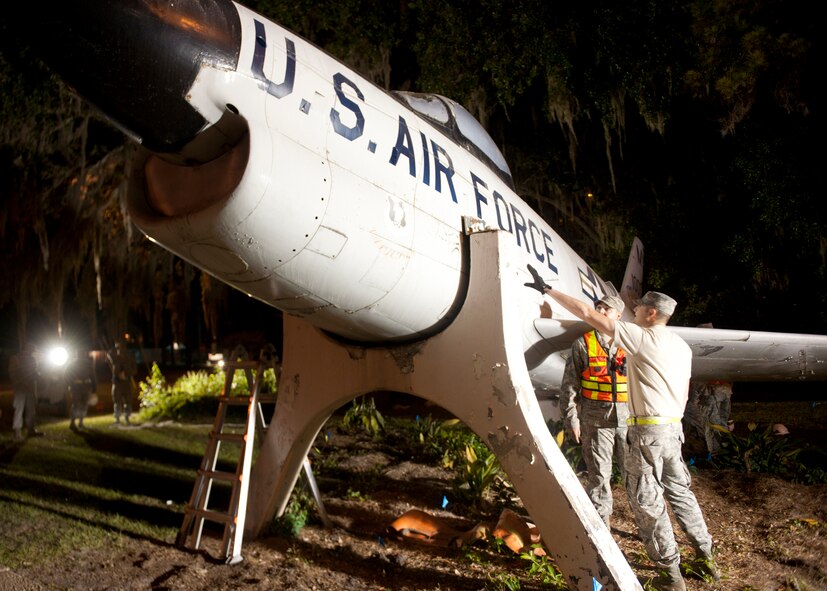 U.S. Air Force Tech Sgt. Thomas Britton, 723d Aircraft Maintenance Squadron, and Staff Sgt. Ryan Adams-Brady, 23d Equipment Maintenance Squadron, discuss the plans in lifting and transporting the F-86L Sabre aircraft from downtown Valdosta, Ga., to Moody Air Force Base April 24, 2012. The aircraft is dedicated to Maj. Lyn McIntosh, a Valdosta native and a rescue pilot killed April 25, 1980, in Operation Iron Claw -- a rescue attempt for Americans held hostage in Tehran, Iran. The F-86 is part of the Flying Tigers heritage and will be added to the George W. Bush Air Park at Moody Field.  (U.S. Air Force photo by Senior Airman Eileen Meier/Released)