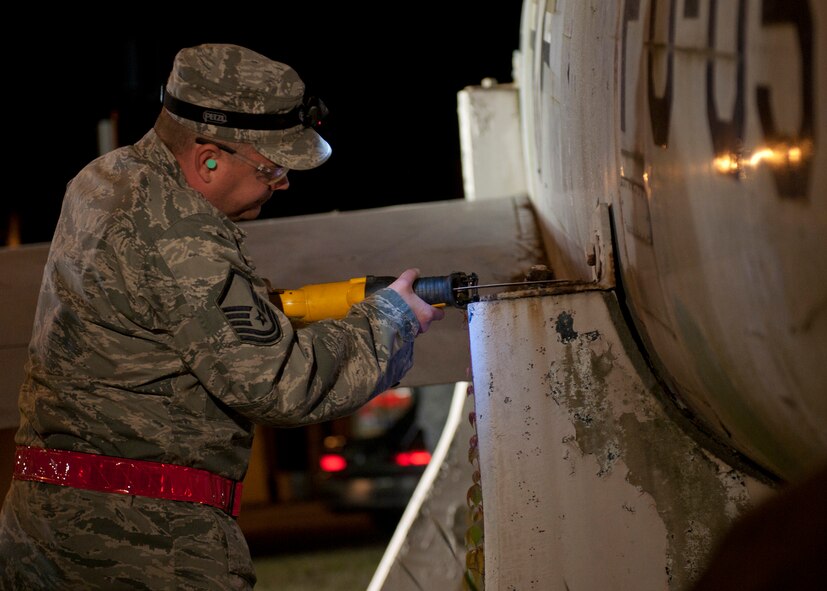 U.S. Air Force Master Sgt. Dale Smith, 23d Equipment Maintenance Squadron, saws off mounting bolts securing an F-86L Sabre to its platform before lifting it onto the flatbed in downtown Valdosta, Ga., April 24, 2012. The aircraft was relocated to Moody Air Force Base, Ga., where it will be refurbished and added to the George W. Bush Air Park at Moody Field to commemorate Flying Tigers heritage. (U.S. Air Force photo by Senior Airman Eileen Meier/Released)
