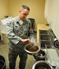 MINOT AIRFORCE BASE, N.D.  - - Tech. Sgt. Randy Akin, 5th Security Forces Squadron military working dog kennel master, prepares morning chow for his canines, here April 24. Military working dogs are kept on a strict feeding schedule due to their rigorous training programs. (U.S. Air Force photo by Senior Airman Desiree W. Esposito) 