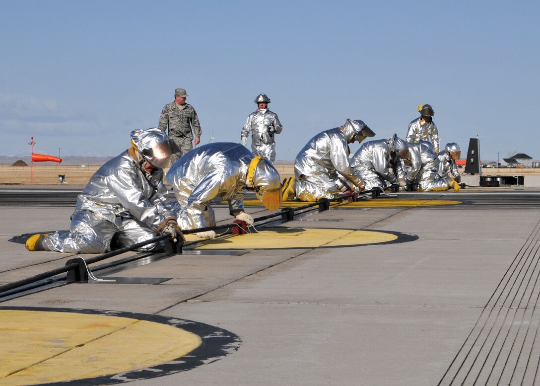 MTANG firefighters replace the barrier cable following a successful test of the end of runway aircraft arresting system.  The certification engagement exercise was held at the Great Falls International Airport on March 4.  (U.S. Air Force photo by Senior Master Sgt. Eric Peterson)