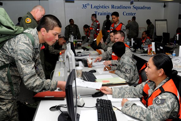 U.S. Air Force Staff Sgt Meliza Duplantis, right, 35th Medical Support Squadron pharmacy technician, processes Airman Harper Le, 35th Aircraft Maintenance Squadron, through the personnel deployment function line portion of an operational readiness exercise at Misawa Air Base, Japan, April 27, 2012. This is Misawa’s first ORE of 2012. (U.S. Air Force photo by Tech. Sgt. Marie Brown/Released)