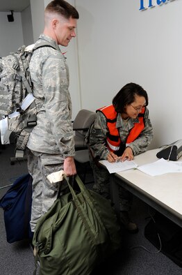 U.S. Air Force Tech. Sgt. Zoe Reeves, right, 35th Logistics Readiness Squadron NCO in charge passenger travel, records the total weight of Capt. Daniel Connors, left, 35th Aircraft Maintenance Squadron, as he processes through a personnel deployment function line portion of an operational readiness exercise at Misawa Air Base, Japan, April 27, 2012. The purpose of the exercise is to test the 35th Fighter Wing’s ability to generate aircraft and deploy combat power anywhere they are asked to deploy to. (U.S. Air Force photo by Tech. Sgt. Marie Brown/Released)