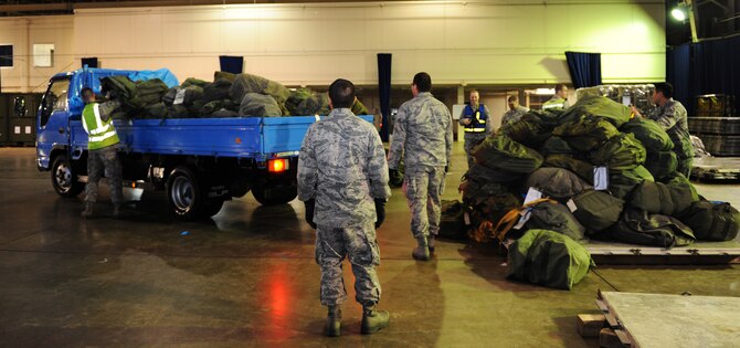 35th Logistics Readiness Squadron augmentees move baggage during an operational readiness exercise at Misawa Air Base, Japan, April 27, 2012. OREs are used to evaluate the operational capability and effectiveness of the wing. (U.S. Air Force photo by Airman 1st Class Kia Atkins/Released)