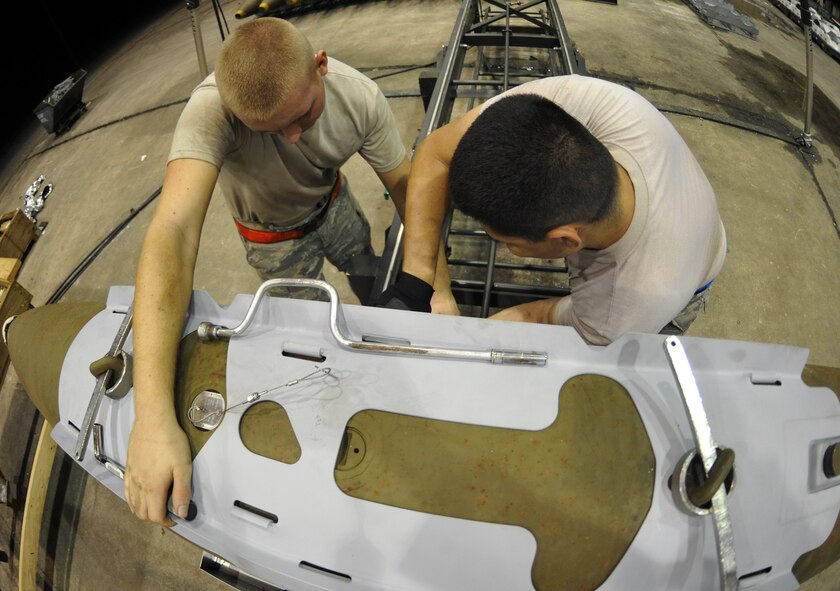 ANDERSEN AIR FORCE BASE, Guam—Two Airmen from the 36th Munitions Squadron attach the Joint Direct Attack Munitions guidance kit to an unguided bomb during the Combat Ammunition Production Exercise April 25. The JDAM is a guidance kit placed on unguided bombs or "dumb bombs" that converts them into all-weather "smart" munitions or guided munitions. (U.S. Air Force photo by Senior Airman Benjamin Wiseman/Released) 
