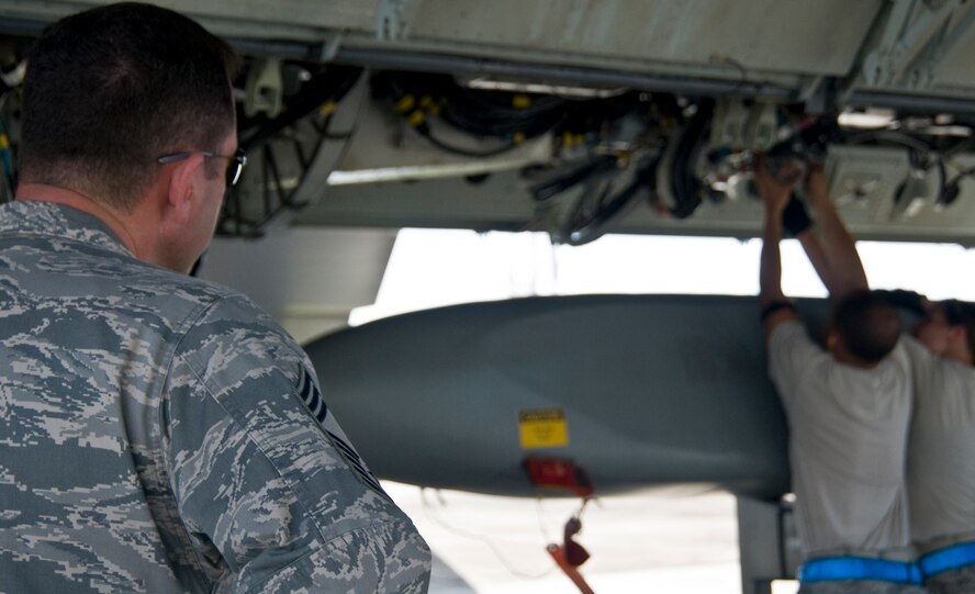 ANDERSEN AIR FORCE BASE, Guam –An Inspector evaluates as Airmen from the 36th Expeditionary Aircraft Maintenance Squadron,  upload a training Conventional Air-Launched Cruise Missile during the Combat Ammunition Production Exercise, Andersen Air Force Base, Guam, April 23, 2012. During the CAPEX approximately 21 inspectors will evaluate the processes and procedures for building munitions to support the wing’s operational plan. (U.S. Air Force photo by Staff Sgt. Alexandre Montes)
