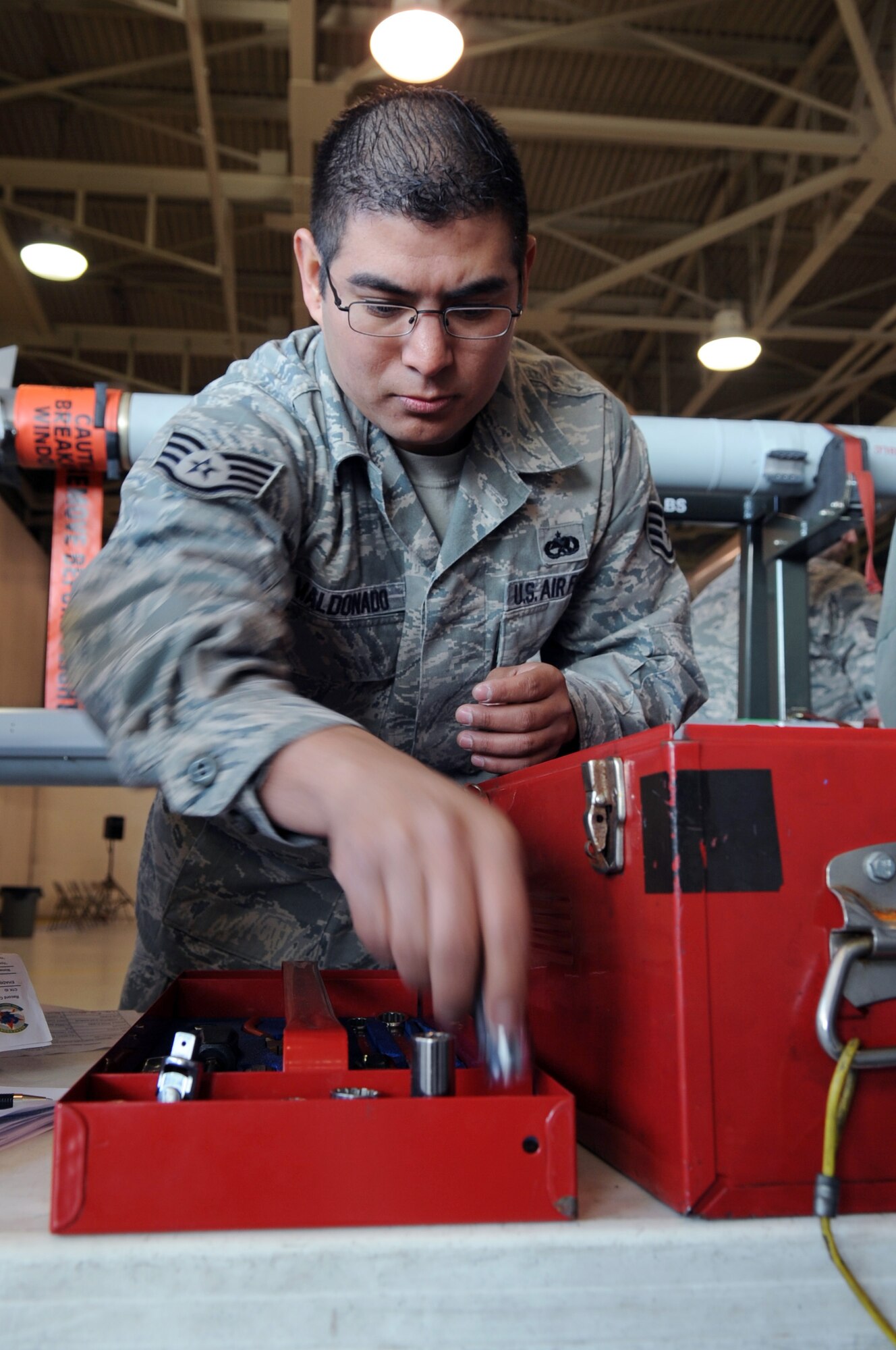 U.S. Air Force Staff Sgt. Jacob Maldonado, 354th Maintenance Squadron technical order distribution officer, inspects a tool box during the composite tool kit scramble at the 354th Maintenance Group Olympics April 20, 2012, Eielson Air Force Base, Alaska. The team that correctly organized all the parts in the tool box in the fastest time won the challenge. (U.S. Air Force photo/Airman 1st Class Lauren-Taylor Garcia)