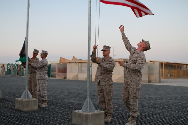 Sergeants Nicholas J. Coban, a native of Pittsburgh, and Bryce W. Cherryholmsnoll, a native of Huxley, Iowa, both U.S. Marines serving with Task Force Leatherneck, 1st Marine Division (Forward), bring down the American flag that was flying over the Task Force Leatherneck compound here April 27, 2012. Marines serving here have the opportunity to fly a 3-by-5-foot American flag for a day and dedicate it to someone of their choice.
