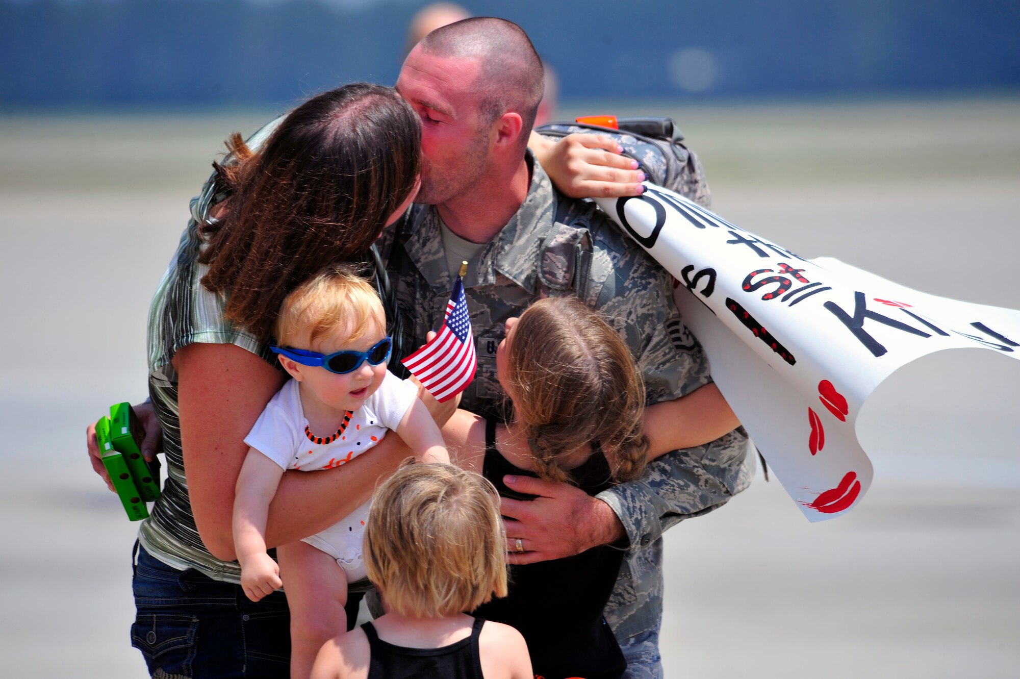 Staff Sgt. Adam Barker, 79th Aircraft Maintenance Unit, is greeted by his wife Ashley, and kids, O'Brian, Ava and Arianna, on the flightline after returning from a seven-month deployment at Shaw Air Force Base, S.C., April 28, 2012. The 79th Fighter Squadron flew the last two combat Air Force aircraft over Iraq providing top cover for the last convoys leaving the country. (U.S. Air Force photo by Senior Airman Daniel Phelps/Released)