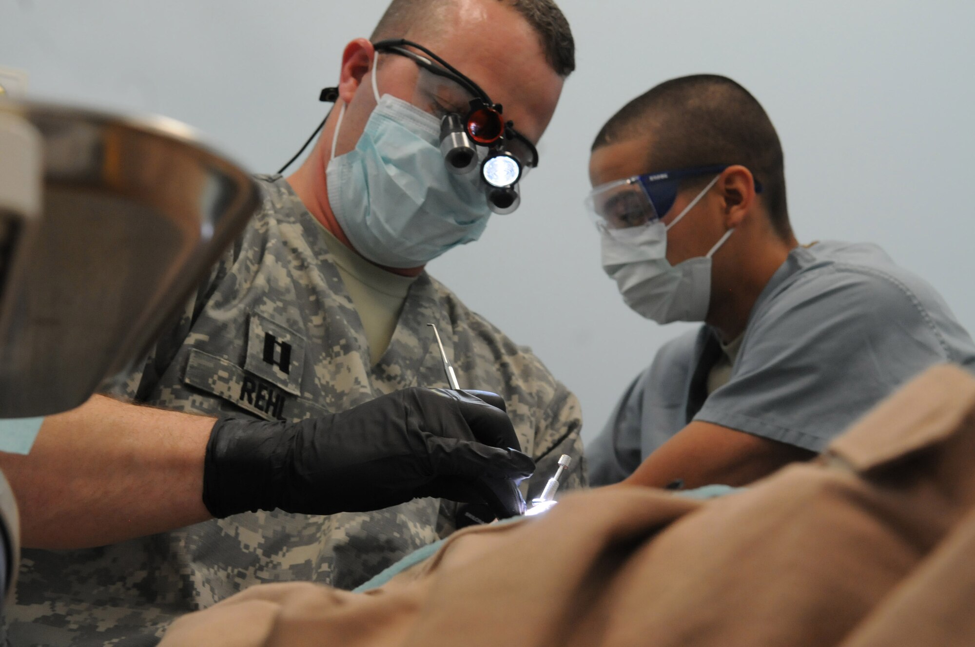 U.S. Army Capt Robert Rehl, general dentist, and Private 1st Class Elisamuel Suarez, dental technician, 502nd Dental Company, Area Support, 1st Medical Brigade, treat Afghan air force Sgt. Mohammad Noori, an Afghan Mi-17 Helicopter flight engineer, for an oral emergency at the Role 3 hospital at Kandahar Air Wing, Afghanistan, April 19, 2012. Rehl, deployed from Fort Knox, Ky., and Suarez, deployed from Fort Hood, Texas are both first time deployers and volunteered for this assignment to KAW. (U.S. Air Force photo by Staff Sgt. Nadine Y. Barclay)