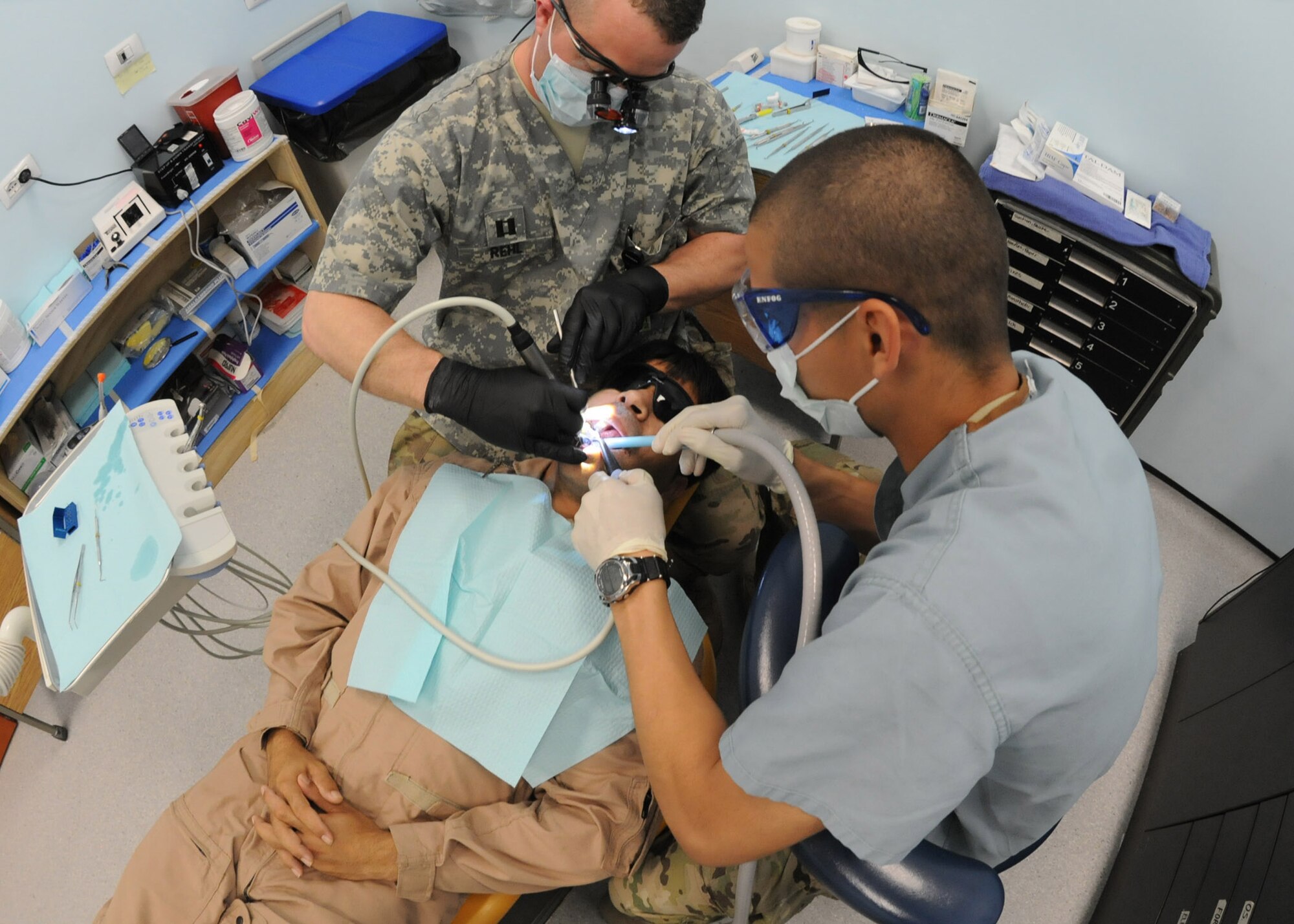 U.S. Army Capt Robert Rehl, general dentist, and Private 1st Class Elisamuel Suarez, dental technician, 502nd Dental Company, Area Support, 1st Medical Brigade, treat Afghan air force Sgt. Mohammad Noori, an Afghan Mi-17 Helicopter flight engineer, for an oral emergency at Kandahar Air Wing, Afghanistan, April 19, 2012. Noori was taken to seek medical attention by advisers from the 738th Air Expeditionary Advisory Group, after he complained of tooth pain during his annual flight physical. Rehl, deployed from Fort Knox, Ky., and Suarez, deployed from Fort Hood, Texas are both first time deployers and volunteered for this assignment to KAW. (U.S. Air Force photo by Staff Sgt. Nadine Y. Barclay)