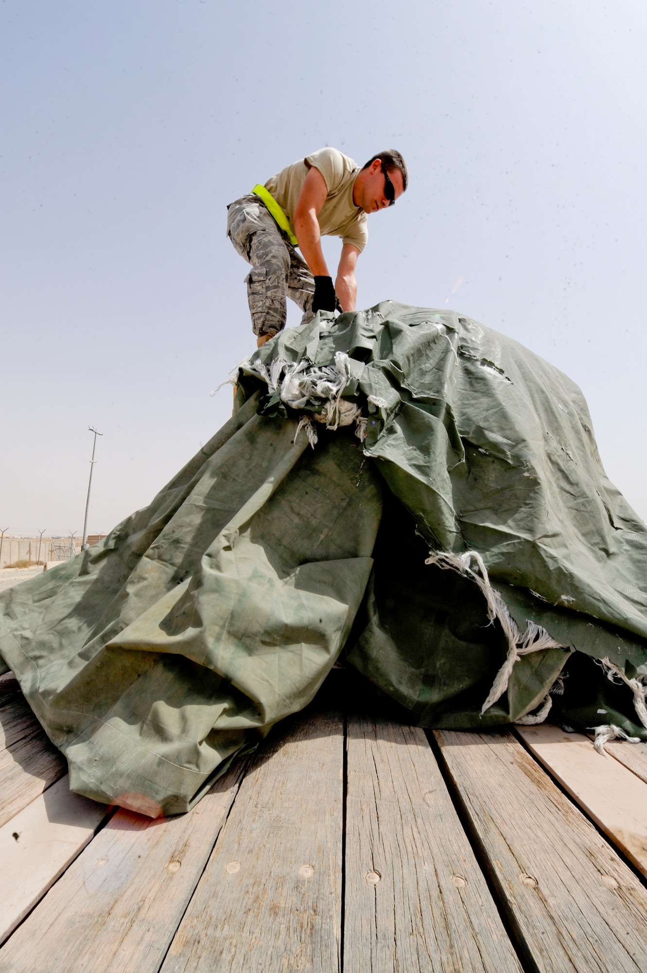 SOUTHWEST ASIA -- Senior Airman Zachary Crutchman, 332nd Expeditionary Logistics Readiness Squadron vehicle operator, removes a tarp from a piece of cargo here, April 26, 2012. The 332nd ELRS transported cargo from the 332nd Air Expeditionary Wing to nearby installations to be shipped to the United States. Crutchman is deployed from Nellis Air Force Base, Nev., and is a native of West Virginia (U.S. Air Force photo by Staff Sgt. Joshua J. Garcia)