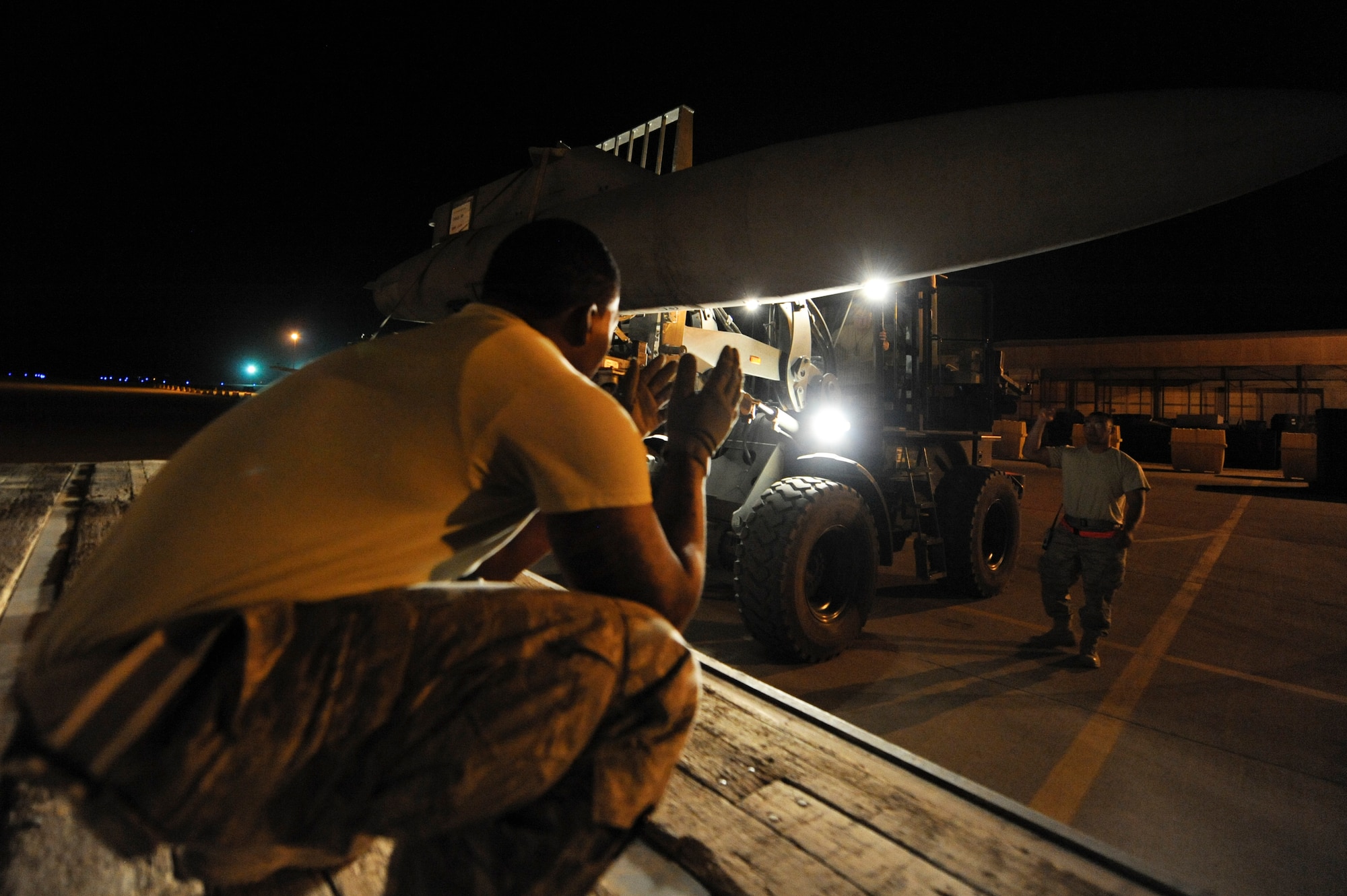 SOUTHWEST ASIA -- Staff Sgt. Quintin Irvin, 332nd Expeditionary Logistics Readiness Squadron vehicle operator, guides a fuselage lodge into place during a cargo upload here, April 25, 2012. The 332nd ELRS convoyed cargo from the 332nd Air Expeditionary Wing to nearby installations. Irvin is deployed from Barksdale Air Force Base, La., and is a native of Pelham, Ga. (U.S. Air Force photo by Staff Sgt. Joshua J. Garcia)