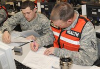 U.S. Air Force Airman 1st Class Joshua Frazer, left, and Staff Sgt. Richard Blake, 35th Aerospace Medicine Squadron public health technicians, process Airmen through the personnel deployment function line during an operational readiness exercise at Misawa Air Base, Japan, April 28, 2012. The purpose of the PDF process is to ensure Airmen have pre-deployment paperwork accomplished prior to supporting contingencies abroad. (U.S. Air Force photo by Airman Kenna Jackson/Released)